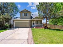 Charming two-story home with a well-maintained lawn, inviting front porch, and attached two-car garage at 5441 Lynx St, Frederick, CO 80504