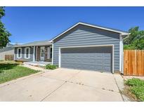 Charming single-story home featuring a two-car garage, and a well-maintained front yard under a clear blue sky at 19155 E Kansas Dr, Aurora, CO 80017