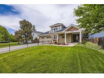 Inviting two-story home featuring a well-manicured lawn, a charming balcony, and a spacious two car attached garage at 940 Kearney St, Denver, CO 80220