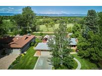 Stunning aerial view of the home featuring lush greenery and mountain views in the background at 2300 Crabtree Dr, Centennial, CO 80121