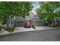 Inviting townhome with attached garage, mature trees, and well-maintained landscaping at 9864 Carmel Ct, Lone Tree, CO 80124