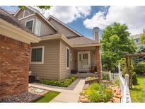 Charming home featuring a welcoming front entrance, well-maintained landscaping, and beautiful garden details at 9864 Carmel Ct, Lone Tree, CO 80124