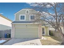 Charming two-story home featuring an attached two-car garage and a well-maintained front yard at 13036 W Cross Dr, Littleton, CO 80127