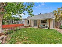 Charming home featuring a well-maintained lawn and a cozy front porch with seating at 936 Utica St, Denver, CO 80204