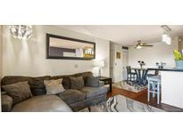 Bright living room featuring a decorative mirror and a neutral-colored sofa at 7881 Allison Way # 204, Arvada, CO 80005