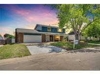 Charming two-story home with brick accents, covered porch, and well-manicured front lawn at 2122 S Zephyr St, Lakewood, CO 80227