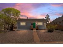 Charming single-story home featuring a well-maintained yard and a welcoming green front door at 128 S Lowell Blvd, Denver, CO 80219