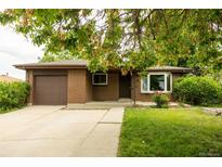 Charming brick home with a well-manicured lawn and a convenient attached garage at 654 S Shoshone St, Denver, CO 80223