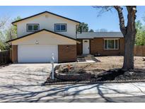 Traditional two-story home featuring brick accents, white siding, and an attached two-car garage at 3256 S Nucla St, Aurora, CO 80013