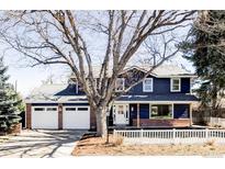 Charming two-story home featuring a two-car garage, brick accents, and a well-maintained front yard at 3100 S Holly Pl, Denver, CO 80222