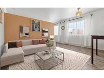 Bright living room with L-shaped sofa, coffee table, and wood-look floors at 855 N Pennsylvania St # 407, Denver, CO 80203