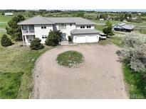An exterior shot of this home features a circular drive and an attached two-car garage at 595 W Oak Hill Ln, Castle Rock, CO 80108
