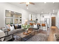 Inviting living room seamlessly connects to a modern kitchen with a breakfast bar and stainless appliances at 20 Wilcox St # 203, Castle Rock, CO 80104