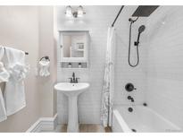 Modern bathroom featuring a pedestal sink, subway tile, and a shower-tub combo with black fixtures at 328 E Dakota Ave, Denver, CO 80209