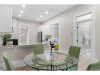 Bright dining area with modern table, chairs and updated kitchen with stainless appliances at 328 E Dakota Ave, Denver, CO 80209