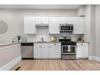 Modern kitchen with stainless steel appliances, white cabinetry, and granite countertops at 328 E Dakota Ave, Denver, CO 80209