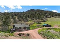 Charming home with a forest backdrop, barn, and large parcel at 15947 S Perry Park Rd, Palmer Lake, CO 80133