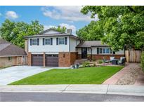 Charming two-story home featuring a well-manicured lawn, brick accents, and a cozy front patio at 14428 W Ellsworth Pl, Golden, CO 80401