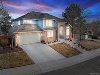 Charming home featuring a brick and siding exterior, two-car garage, and well-maintained landscaping at 17076 W 71St Pl, Arvada, CO 80007