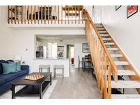 Bright living space features a loft, open staircase, and view into the updated kitchen at 3026 W Prentice Ave # H, Littleton, CO 80123
