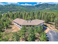 Stunning hillside home surrounded by evergreens featuring a wrap-around design and mountain views at 30671 Bearcat Trl, Conifer, CO 80433