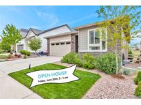 Inviting front exterior with manicured lawn, beautiful stone accents, and a convenient two-car garage at 9055 Swan River St, Littleton, CO 80125