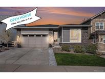 Charming single-story home featuring a well-manicured lawn, stone accents, and an attached two-car garage at 9055 Swan River St, Littleton, CO 80125