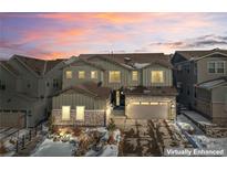 Two-story home with stone and siding accents, attached garage, and landscaping at 6922 Copper Sky Cir, Castle Pines, CO 80108