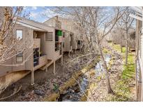Exterior view of a multi-story home with creek running through the property, showcasing the building's architecture at 6700 W 11Th Ave # 202, Lakewood, CO 80214