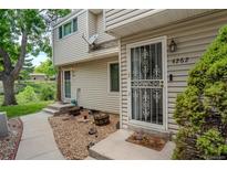 Charming townhome entrance featuring decorative door and manicured landscape at 4262 E Maplewood Way, Centennial, CO 80121