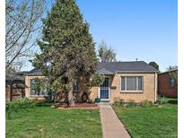 Charming single story home boasts a lush front lawn, mature tree, and welcoming walkway to the front door at 4530 S Pennsylvania St, Englewood, CO 80113