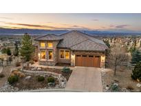 Stunning single-Gathering home features a stone and tile exterior, a two-car garage, and a well-manicured front yard at 10693 Mountaingate Ct, Highlands Ranch, CO 80126