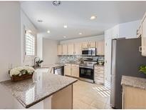 Well-lit kitchen with granite countertops, stainless steel appliances, and ample cabinet space at 112 W Sterne Pkwy, Littleton, CO 80120