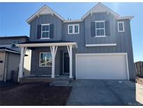 Charming two-story home with gray siding, white trim, a two-car garage, and a covered porch at 8836 Whiteclover St, Littleton, CO 80125