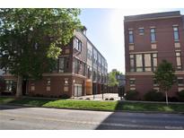 Modern townhomes with red brick exteriors and well-maintained front lawns near a paved street at 2147 N Downing St, Denver, CO 80205