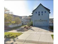 Two-story home features a spacious driveway, attached garage, manicured lawn, and a light-blue exterior at 4628 Mt Shavano St, Brighton, CO 80601