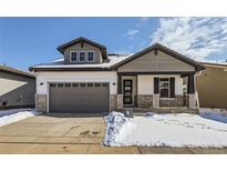 Beautiful two-story home with stone accents, gray trim, a two-car garage, and snow-covered landscaping at 2962 Newfound Lake Rd, Berthoud, CO 80513