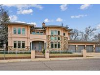 Stunning two-story home with stone accents, a gated yard, and a three-car garage at 115 S Jasmine St, Denver, CO 80224