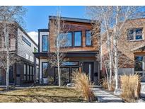 Contemporary two-story home with a modern design, contrasting wood and brick, and professional landscaping at 3615 Lipan St, Denver, CO 80211