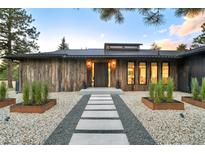 Modern home with rustic wood siding and a stone walkway leading to the front door at 18910 Augusta Dr, Monument, CO 80132