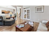 Bright living room boasts hardwood floors, neutral paint, and natural light at 9471 Crossland Way, Highlands Ranch, CO 80130