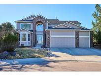 Charming two-story home with a three-car garage and well-manicured front yard at 2460 Switch Grass Way, Castle Rock, CO 80109