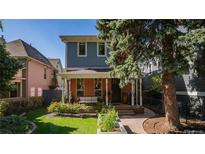 Charming two-story home featuring a brick facade, inviting front porch and a well-manicured front yard at 1745 N Emerson St, Denver, CO 80218