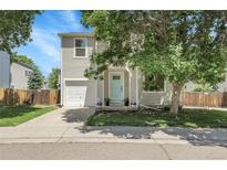 Charming home with a light blue front door, attached garage, and landscaped front yard at 11757 W Tufts Pl, Morrison, CO 80465
