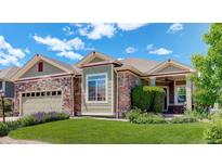 Charming single-Gathering home featuring a stone and green siding, manicured lawn, and attached garage at 14879 Xenia St, Thornton, CO 80602