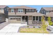 Charming two-story home showcasing stone accents, manicured lawn, and welcoming entrance at 17121 Desert Wine Ln, Parker, CO 80134