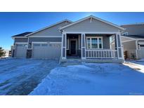 Two-story house with gray siding, covered porch, and a two-car garage at 25086 E 41St Ave, Aurora, CO 80019