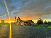 Scenic view of the barn with a breathtaking sunset backdrop, enhancing the property's rustic charm at 5557 Aspen Ave, Erie, CO 80516