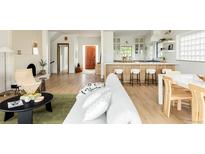 Bright living space with open layout to kitchen, features wood floors, modern decor, and ample natural light at 3445 S Clermont St, Denver, CO 80222