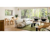 Bright and airy living room featuring hardwood floors, modern furniture and large sliding glass doors to the backyard at 3445 S Clermont St, Denver, CO 80222